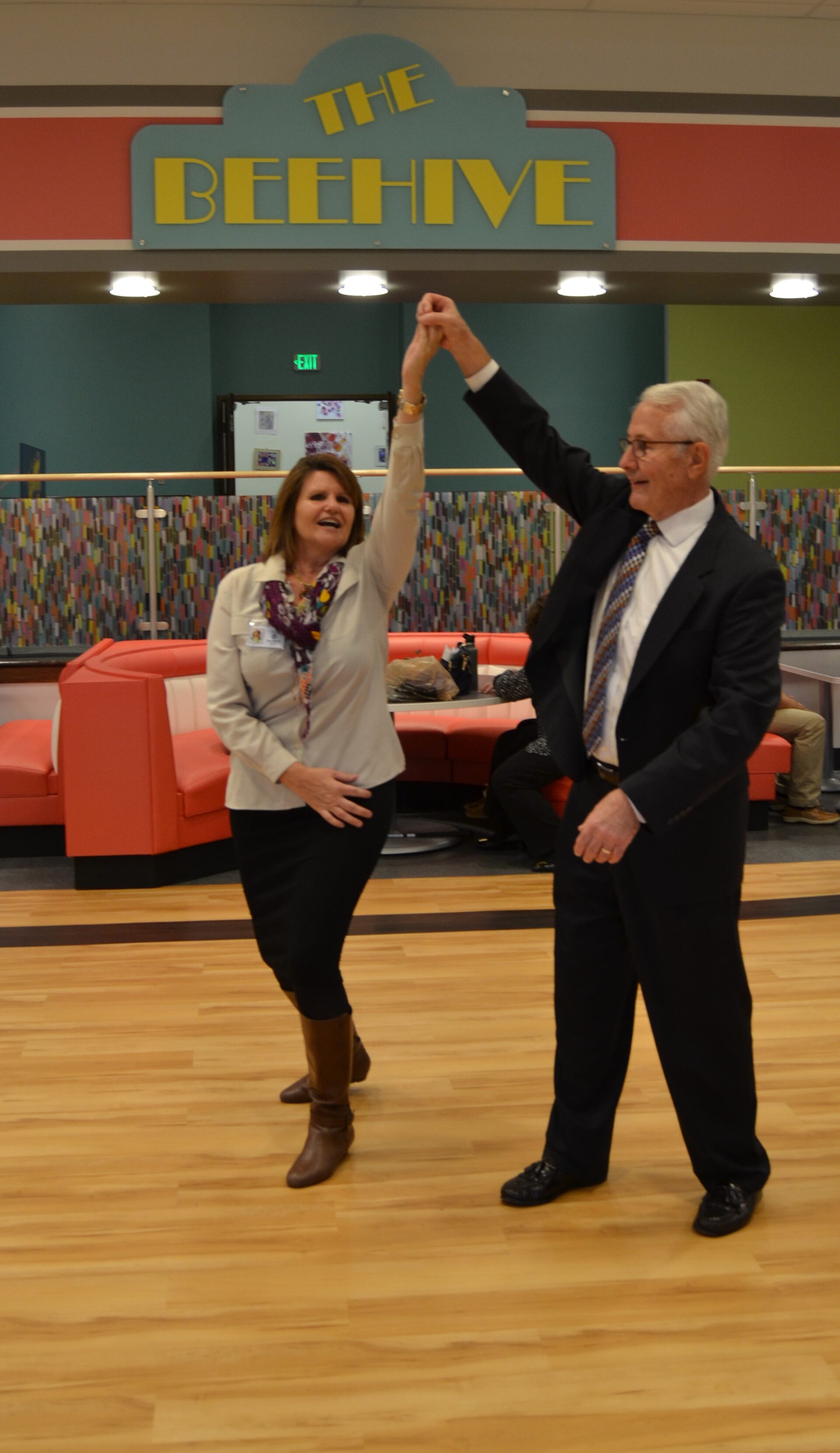 a man and woman dancing on a wooden floor.