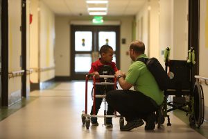 student in walking trainer with O&M instructor