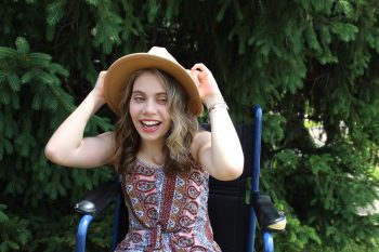 a woman sitting in a chair with a hat on her head.