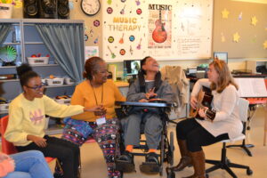 Music Therapist plays guitar for students in class