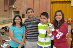 four people (mother, father and two teenagers) stand together for a family photo