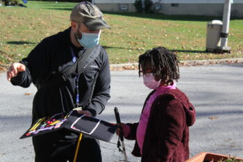 Male teacher shows map to female student with cane