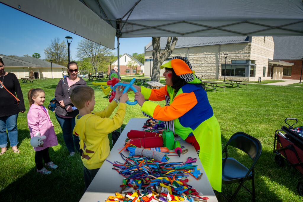 clown making balloon animals for children