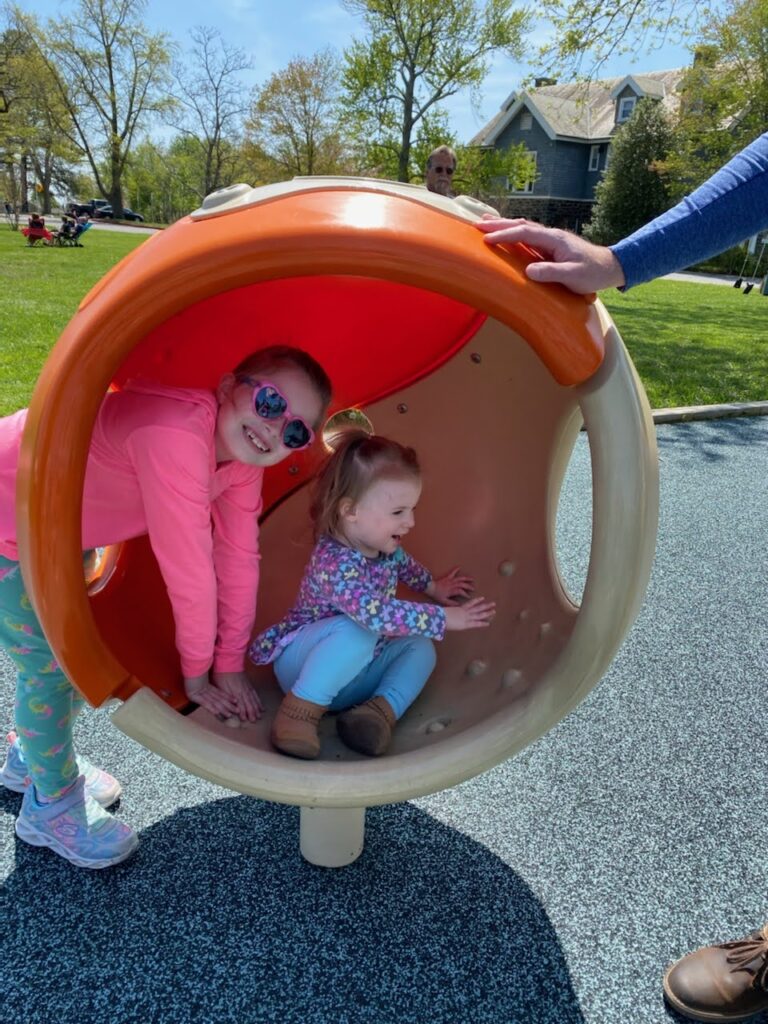 two children play on playground equipment