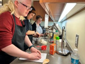 a group of women in a kitchen preparing food.