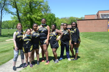 seven female athletes wearing uniforms stand together in line