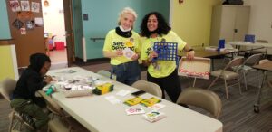 a couple of women standing next to each other at a table.