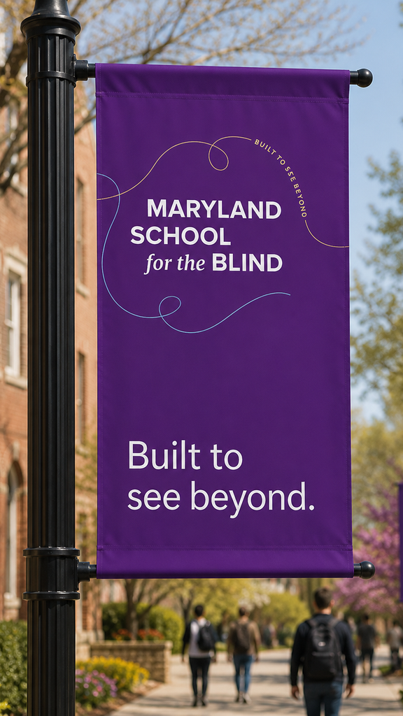 A purple street pole banner near campus reading "Maryland School for the Blind, Built to see beyond," with the new wordmark and swirl line graphic, students walking past in the background.
