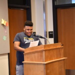 A young man standing at a podium and giving a speech.