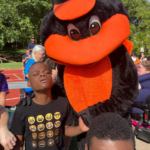 Baltimore orioles mascot posing with a young boy.