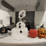 A display of pumpkins and a snowman on a table.
