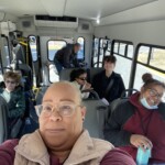 A group of people on a bus taking a selfie.